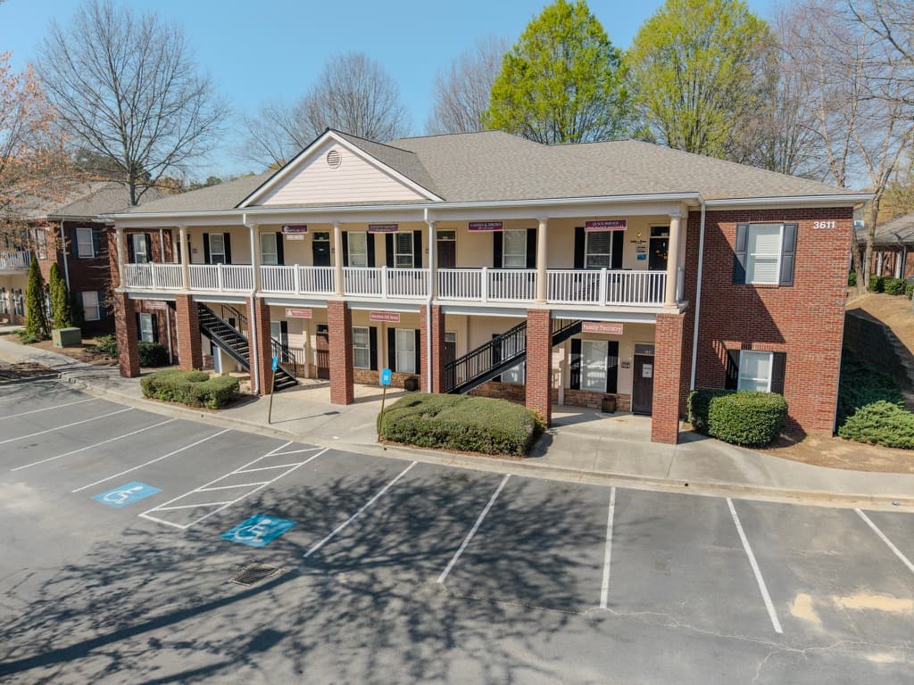Aerial view of a brick business suites building with front parking