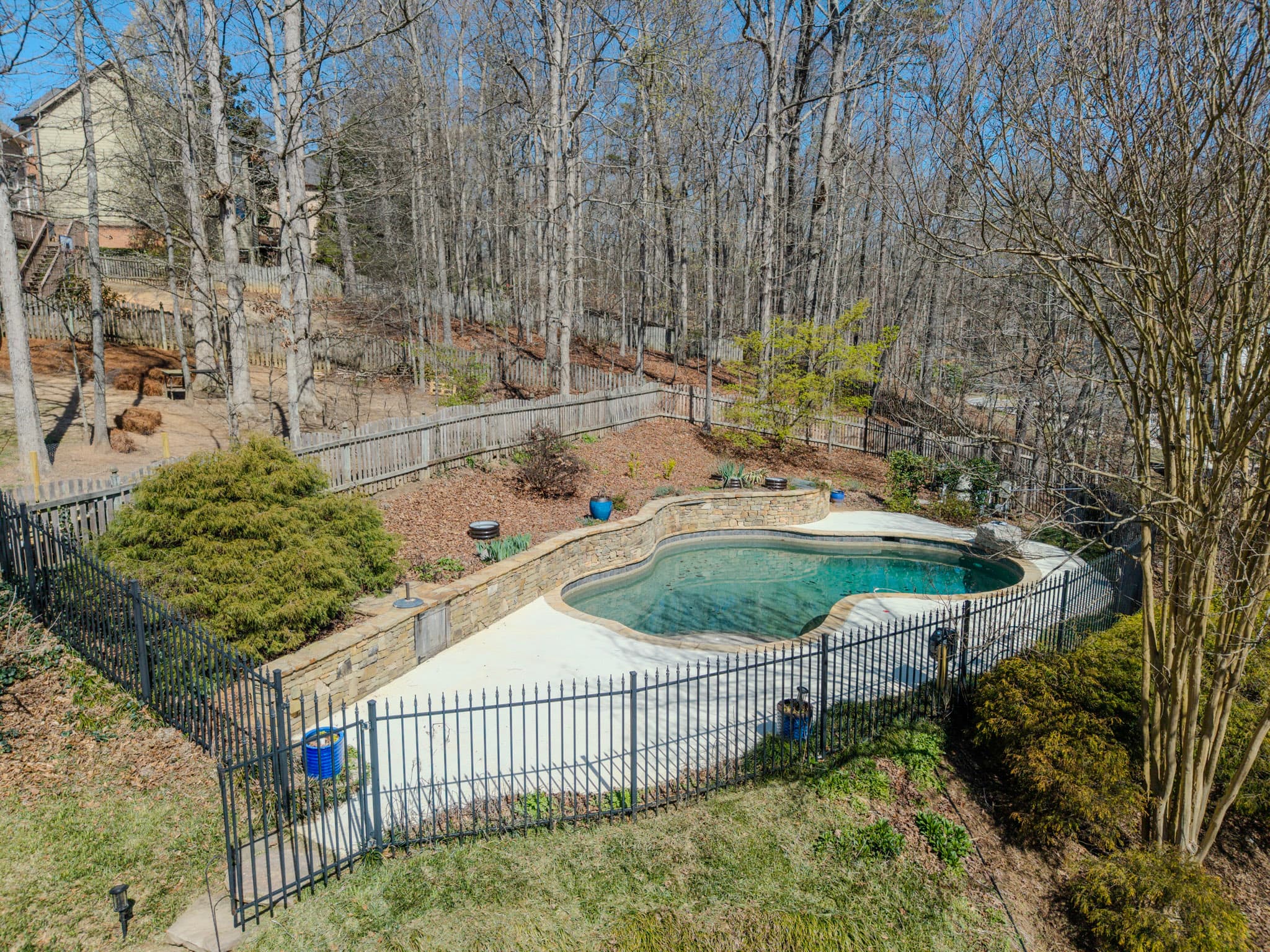 High aerial view of a backyard pool and surrounding property