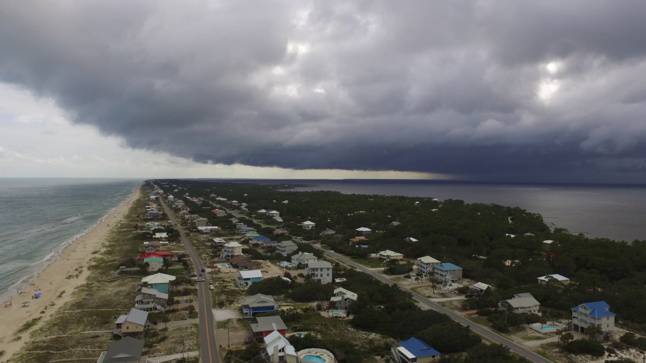 Storm clouds rolling over a coastal road and shoreline